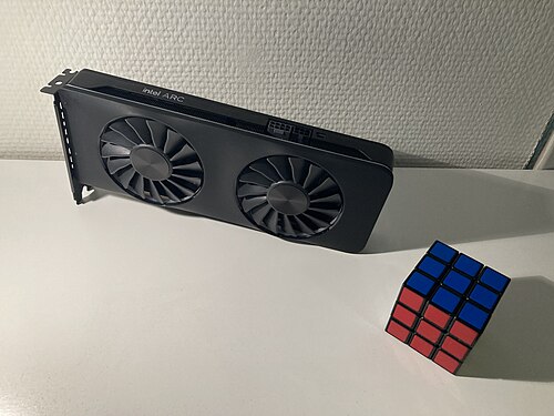 An Intel Arc A770 16 GB, the highest-end desktop GPU from Intel's first generation Alchemist GPUs, with a Rubik's Cube for scale